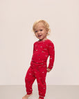 Model wears Kids Printed TENCEL™ Modal Unisex Long PJ Set in Winter Wonderland Haute Red/Ivory.