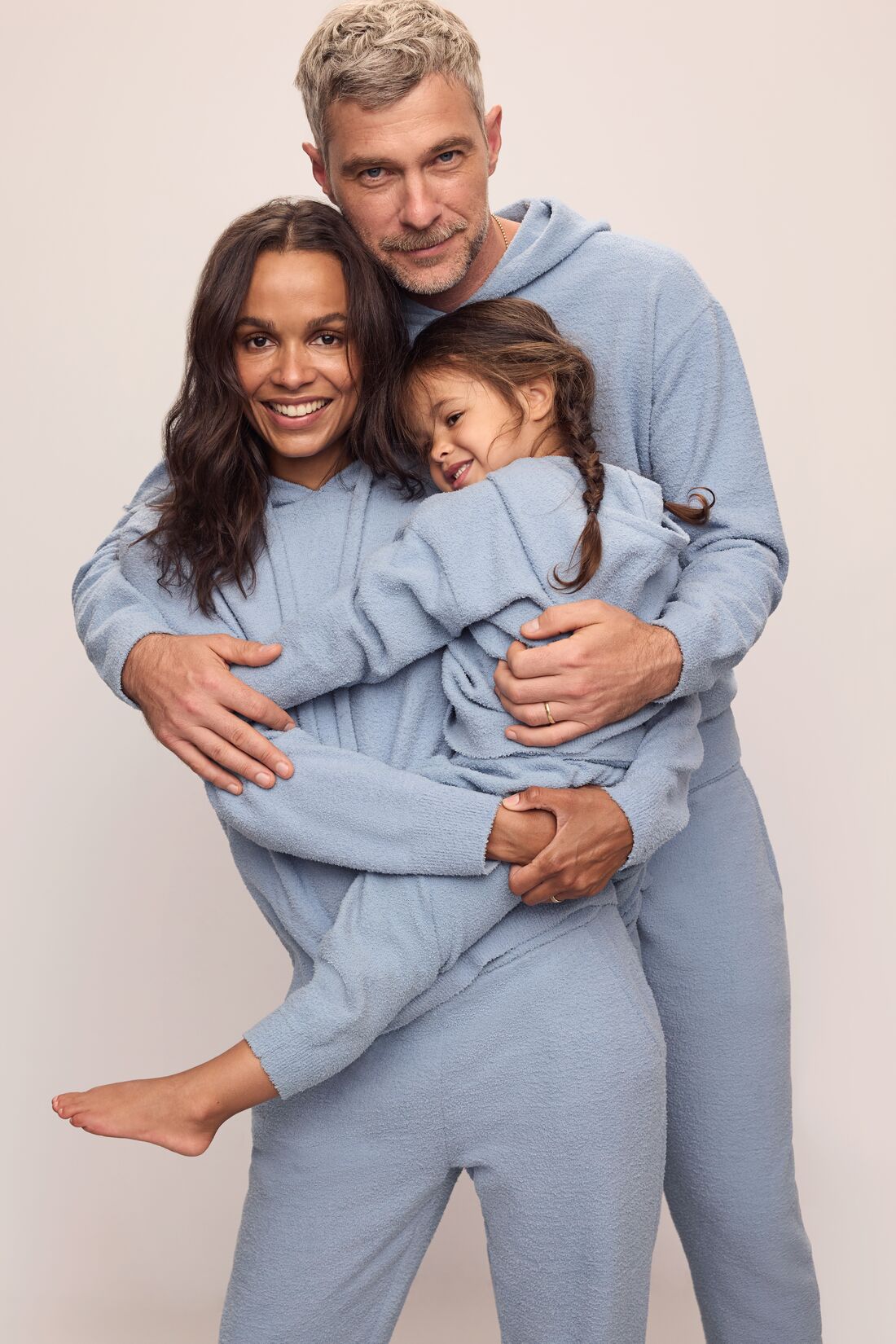 Family image of models in Recycled Boucle Men&#39;s Hoodie and Pant, Women&#39;s Hoodie and Jogger, and Kid&#39;s Hoodie and Jogger Set in Wedgewood