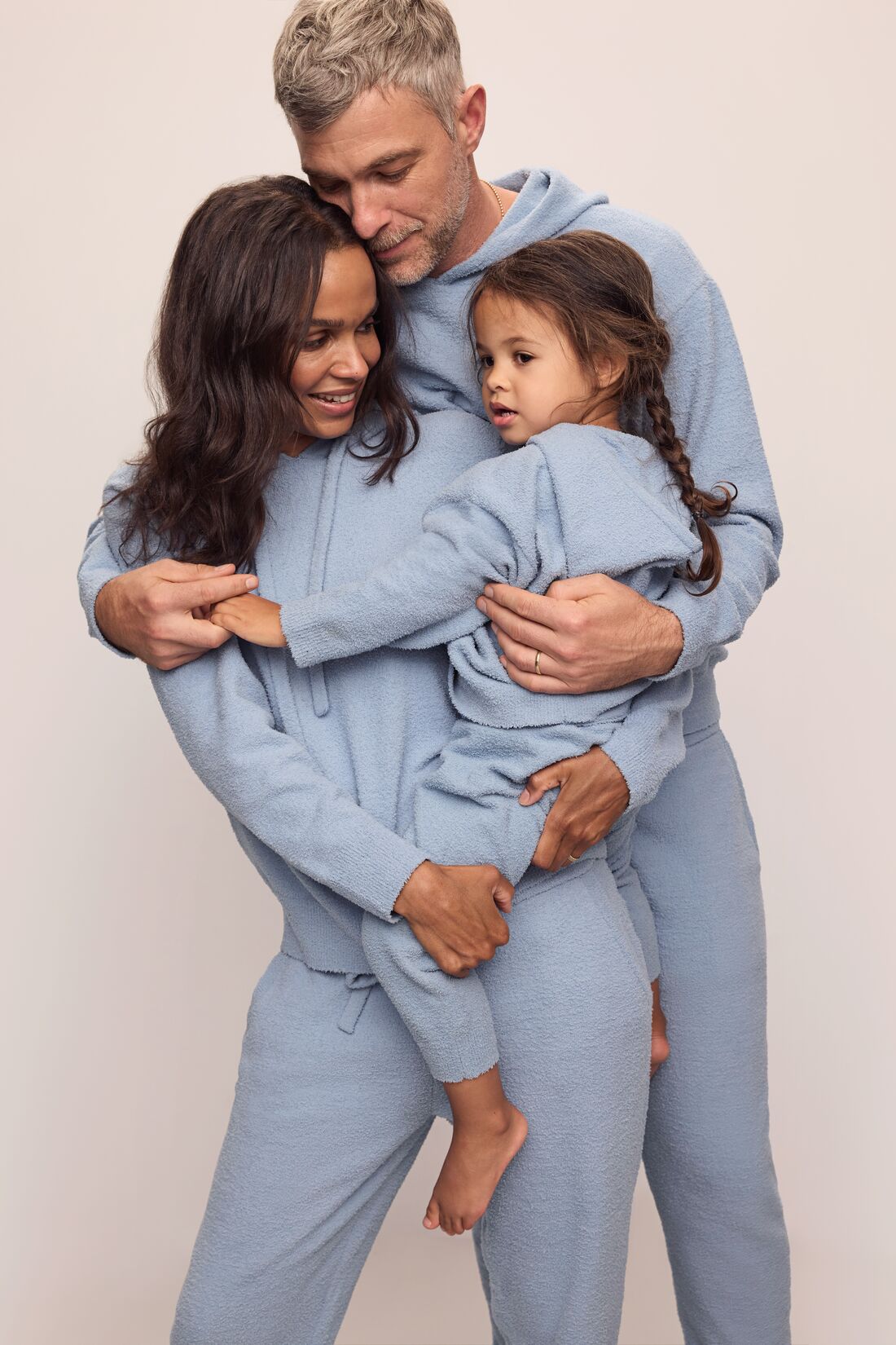 Family image of models in Recycled Boucle Men&#39;s Hoodie and Pant, Women&#39;s Hoodie and Jogger, and Kid&#39;s Hoodie and Jogger Set in Wedgewood