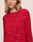 Model wears the Gisele Printed TENCEL™ Modal Crewneck PJ Set in Winter Wonderland Haute Red/Ivory.