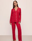 Model wears the Gisele Printed TENCEL™ Modal Long PJ Set in Winter Wonderland Haute Red/Ivory.