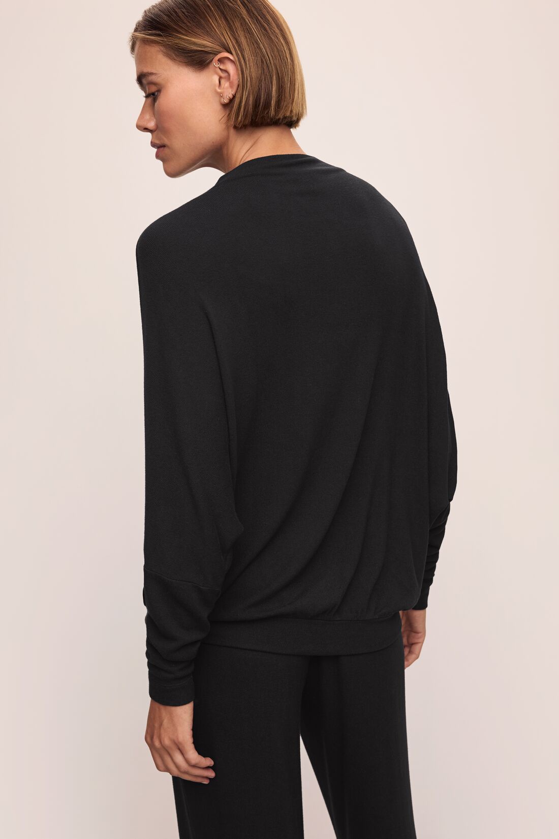 Model wears Cozy Time Mock Neck Pullover in Black.