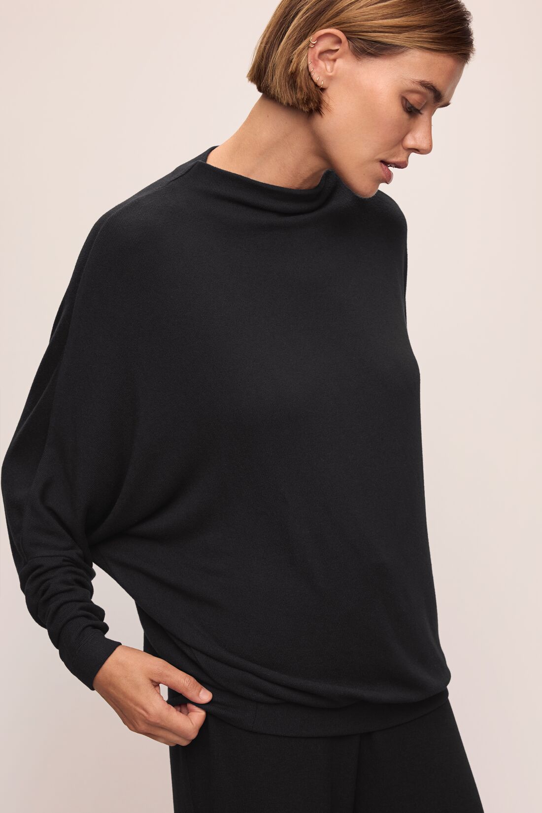 Model wears Cozy Time Mock Neck Pullover in Black.