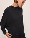 Model wears Cozy Time Mock Neck Pullover in Black.