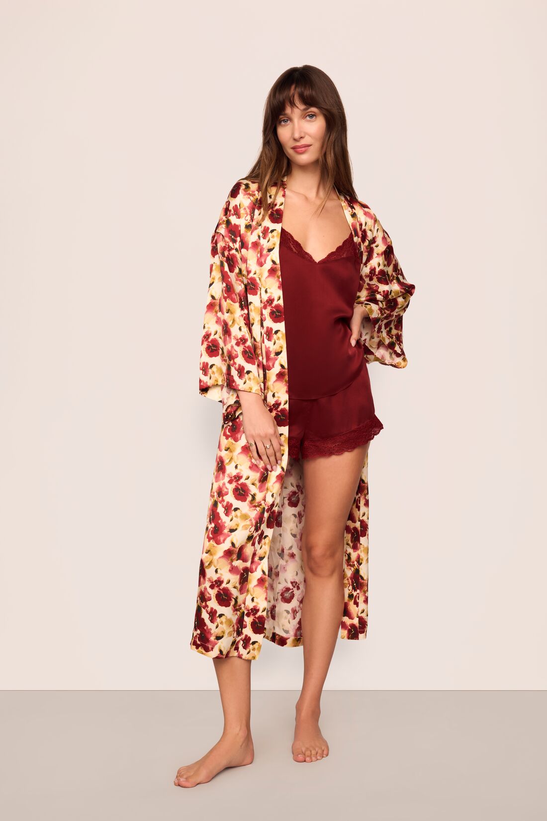 Model is wearing Inez Washable Silk Long Robe in Botanical Flower Merlot and Washable Silk Lace Cami and Short Set in Merlot/Merlot