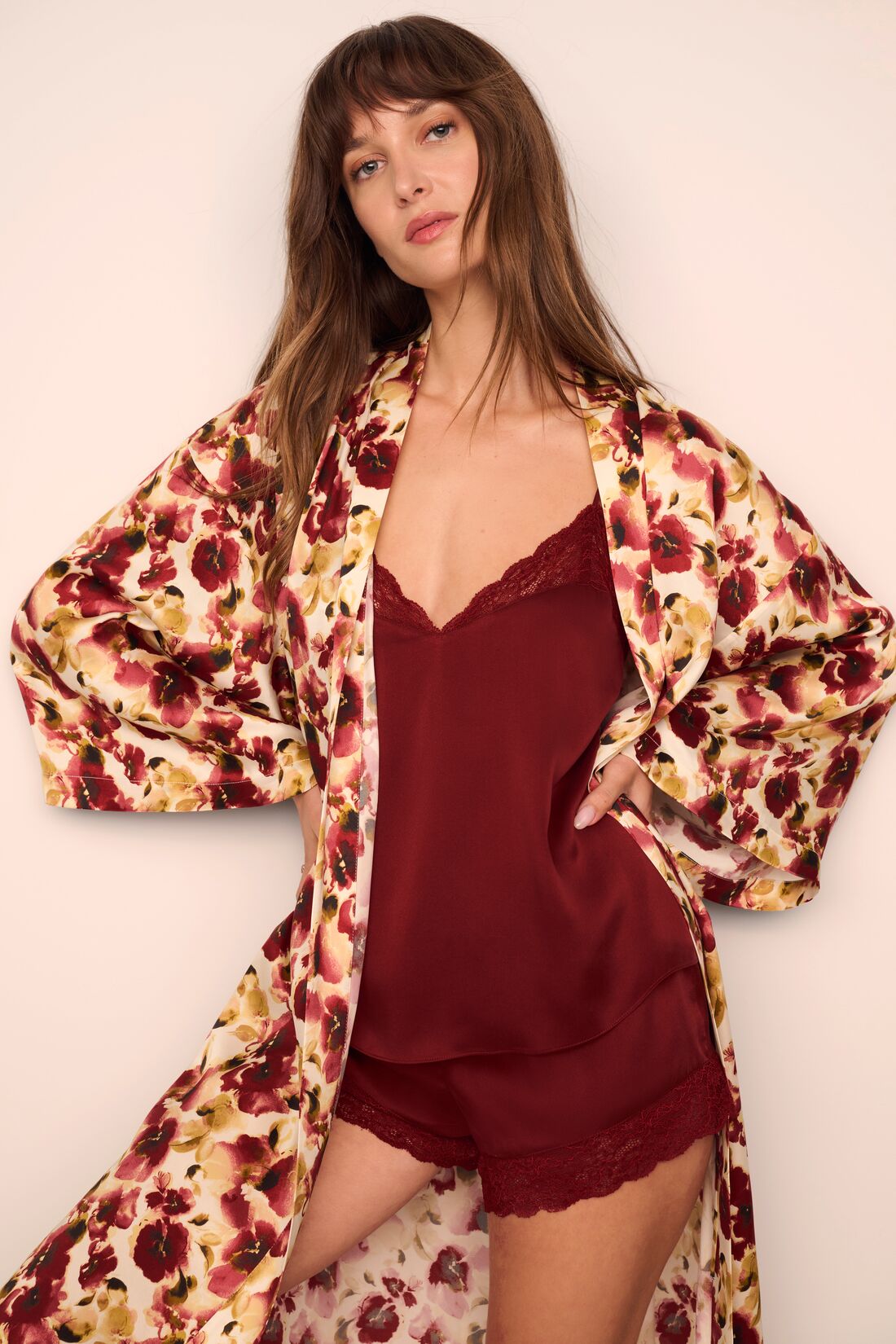 Model is wearing Inez Washable Silk Long Robe in Botanical Flower Merlot and Washable Silk Lace Cami and Short Set in Merlot/Merlot