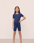 Model is wearing Kids TENCEL™ Modal Unisex Short PJ Set in Navy/Ivory