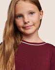 Model is wearing Kids TENCEL™ Modal Unisex Long PJ Set  in Bordeaux/Ivory