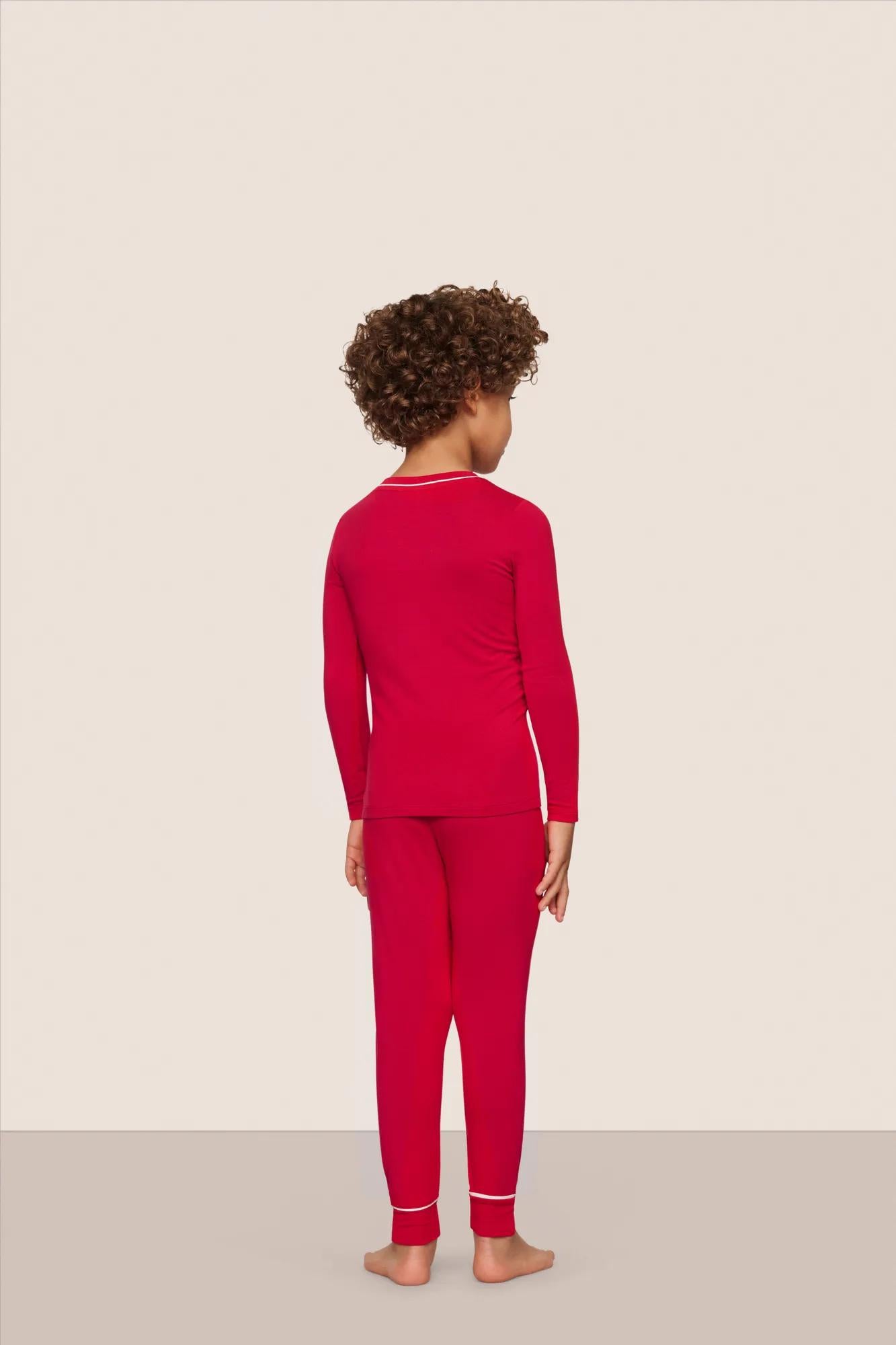 Model is wearing Kids TENCEL™ Modal Unisex Long PJ Set  in Holly Red/Ivory