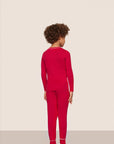 Model is wearing Kids TENCEL™ Modal Unisex Long PJ Set  in Holly Red/Ivory