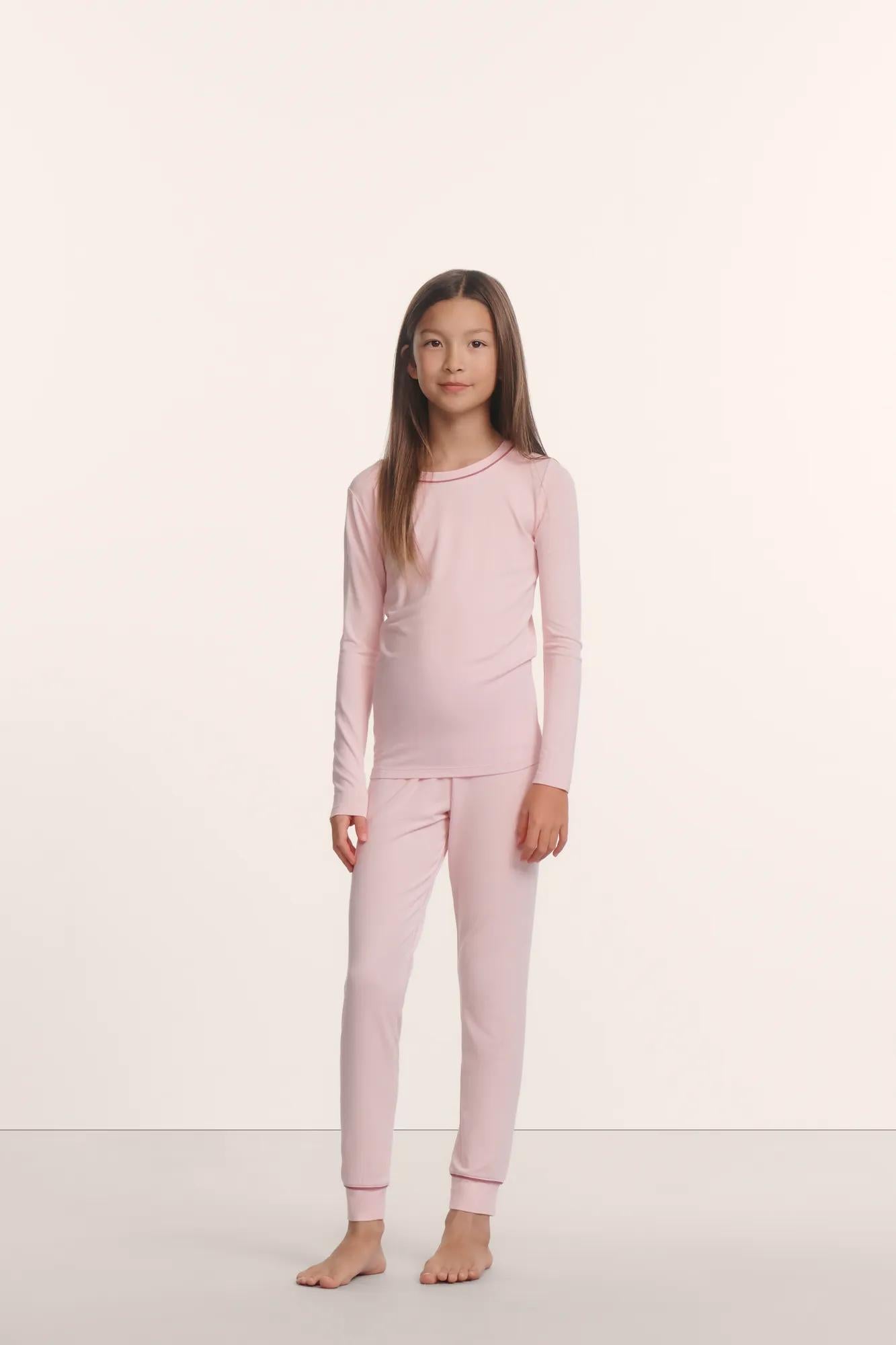 Model is wearing Kids TENCEL™ Modal Unisex Long PJ Set in Pale Pink/Fig