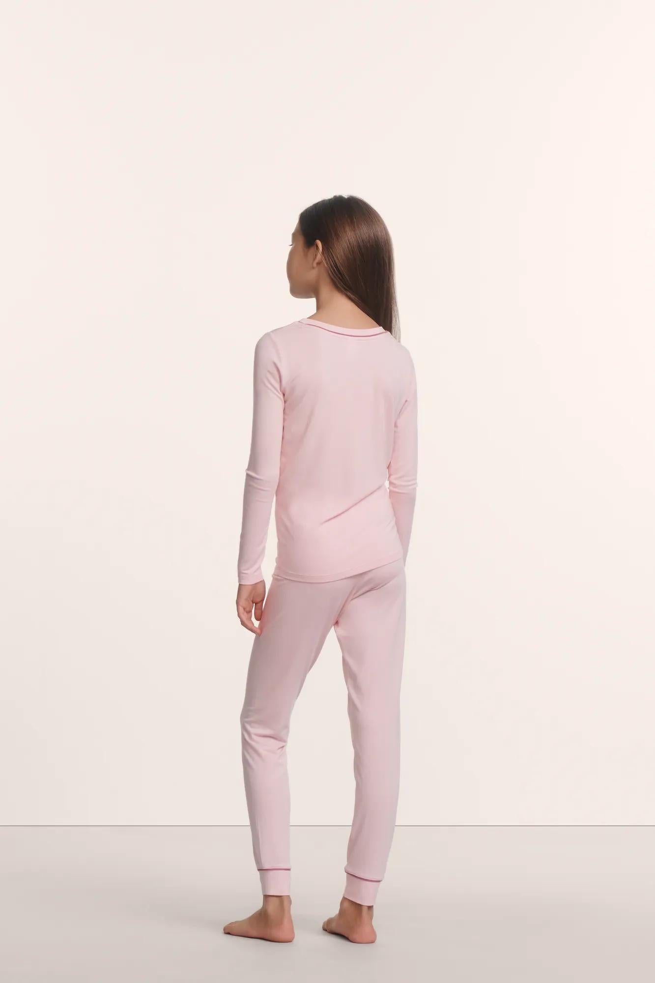 Model is wearing Kids TENCEL™ Modal Unisex Long PJ Set in Pale Pink/Fig