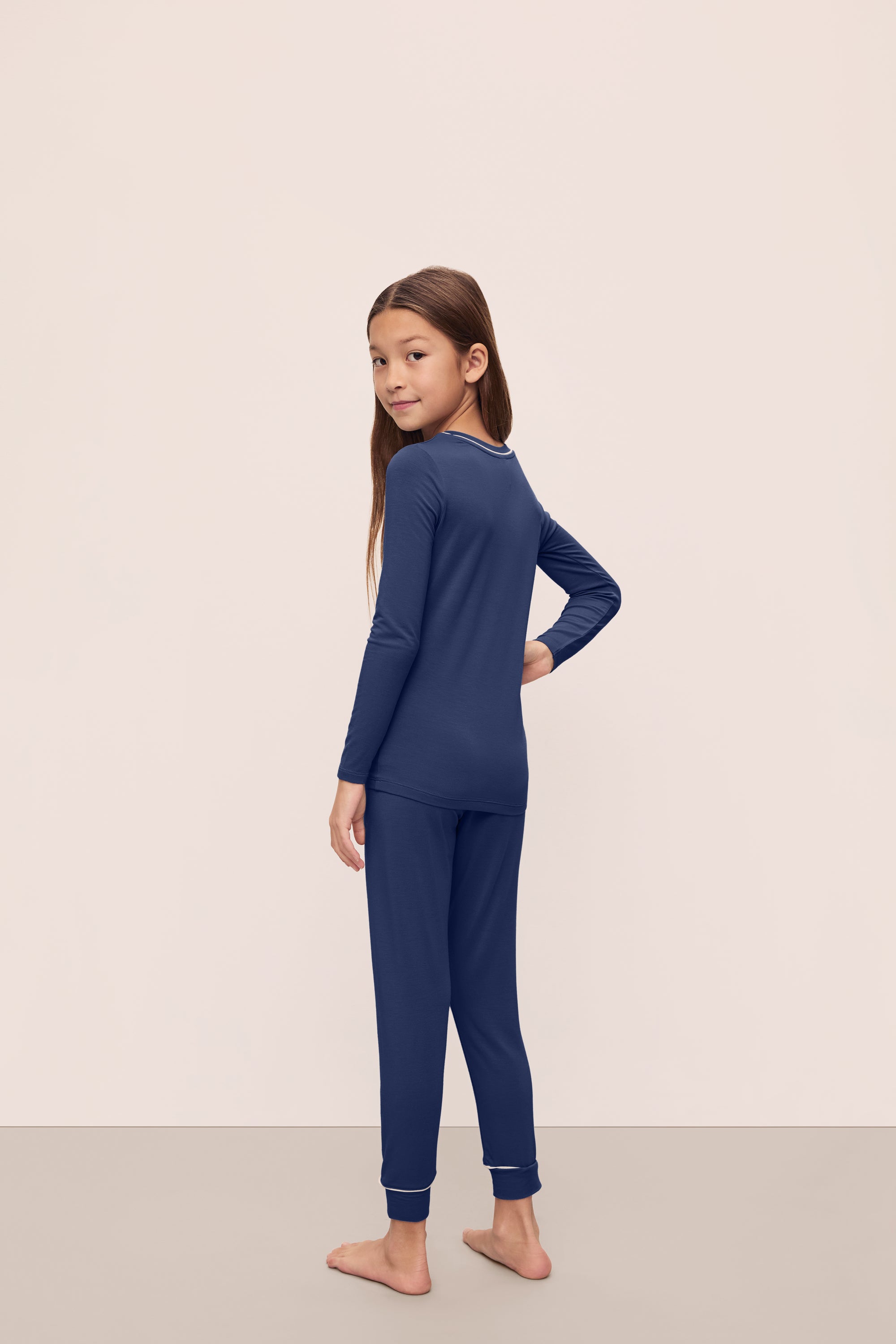 Model is wearing Kids TENCEL™ Modal Unisex Long PJ Set in Navy/Ivory