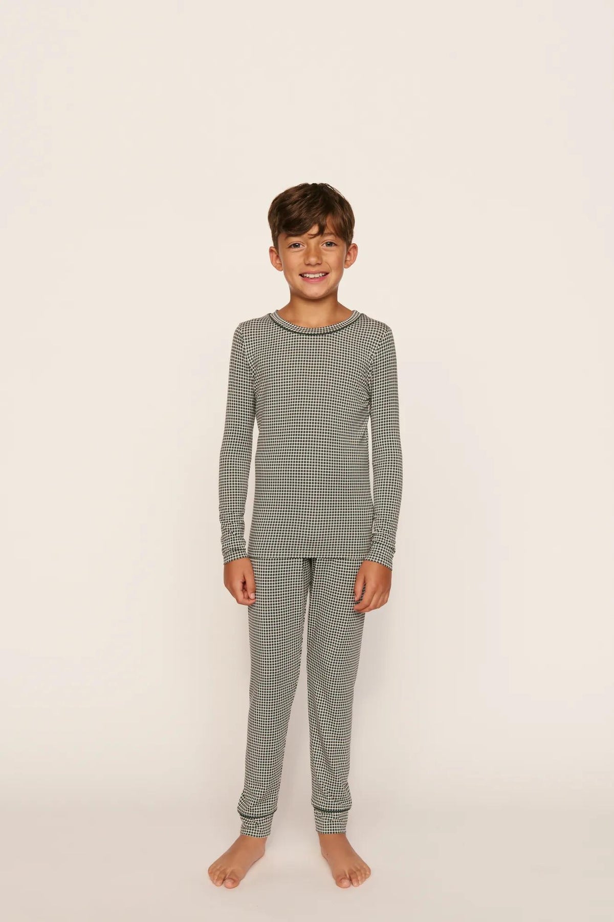Model is wearing Kids Printed TENCEL™ Modal Unisex Long PJ Set in Cabin Check Ivory/Pine