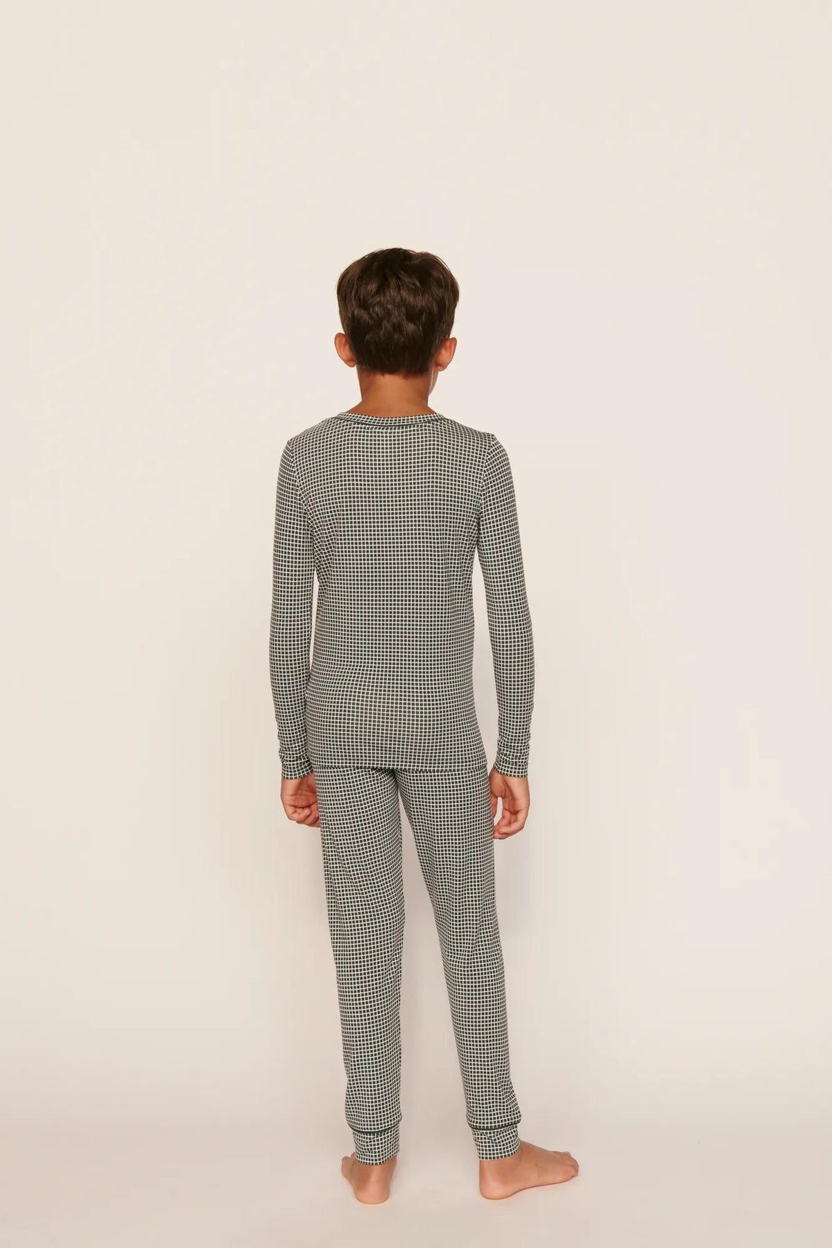 Model is wearing Kids Printed TENCEL™ Modal Unisex Long PJ Set in Cabin Check Ivory/Pine