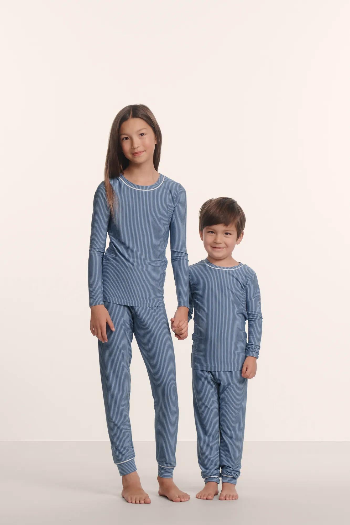 Model is wearing Kids Printed TENCEL™ Modal Unisex Long PJ Set in Duo Stripe Slate Blue/Ivory