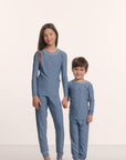 Model is wearing Kids Printed TENCEL™ Modal Unisex Long PJ Set in Duo Stripe Slate Blue/Ivory