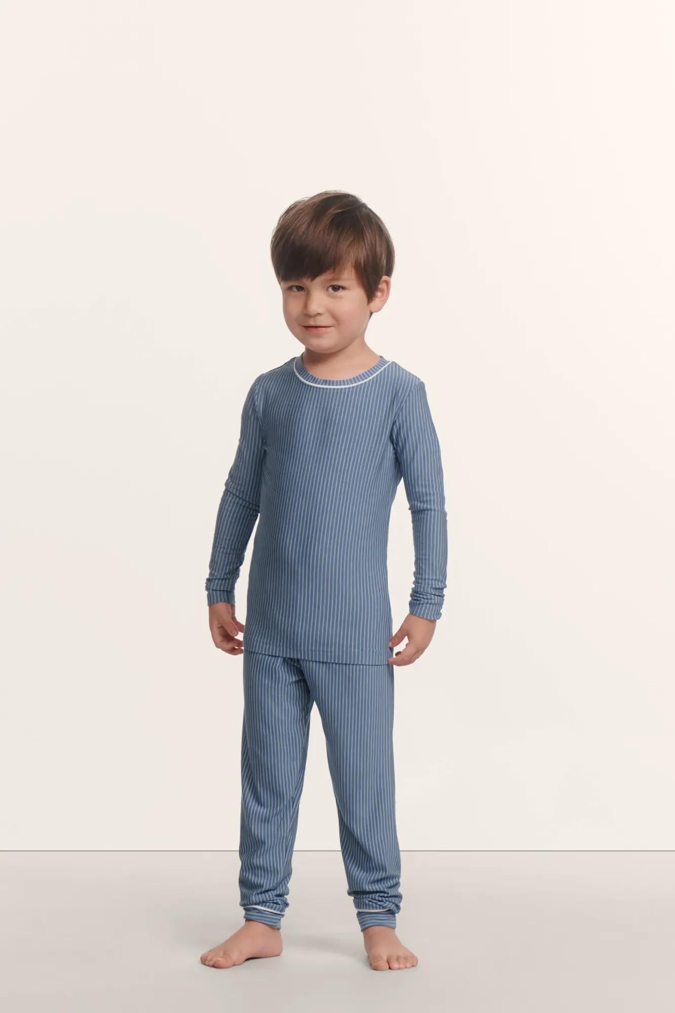 Model is wearing Kids Printed TENCEL™ Modal Unisex Long PJ Set in Duo Stripe Slate Blue/Ivory