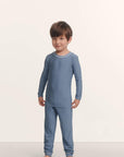 Model is wearing Kids Printed TENCEL™ Modal Unisex Long PJ Set in Duo Stripe Slate Blue/Ivory