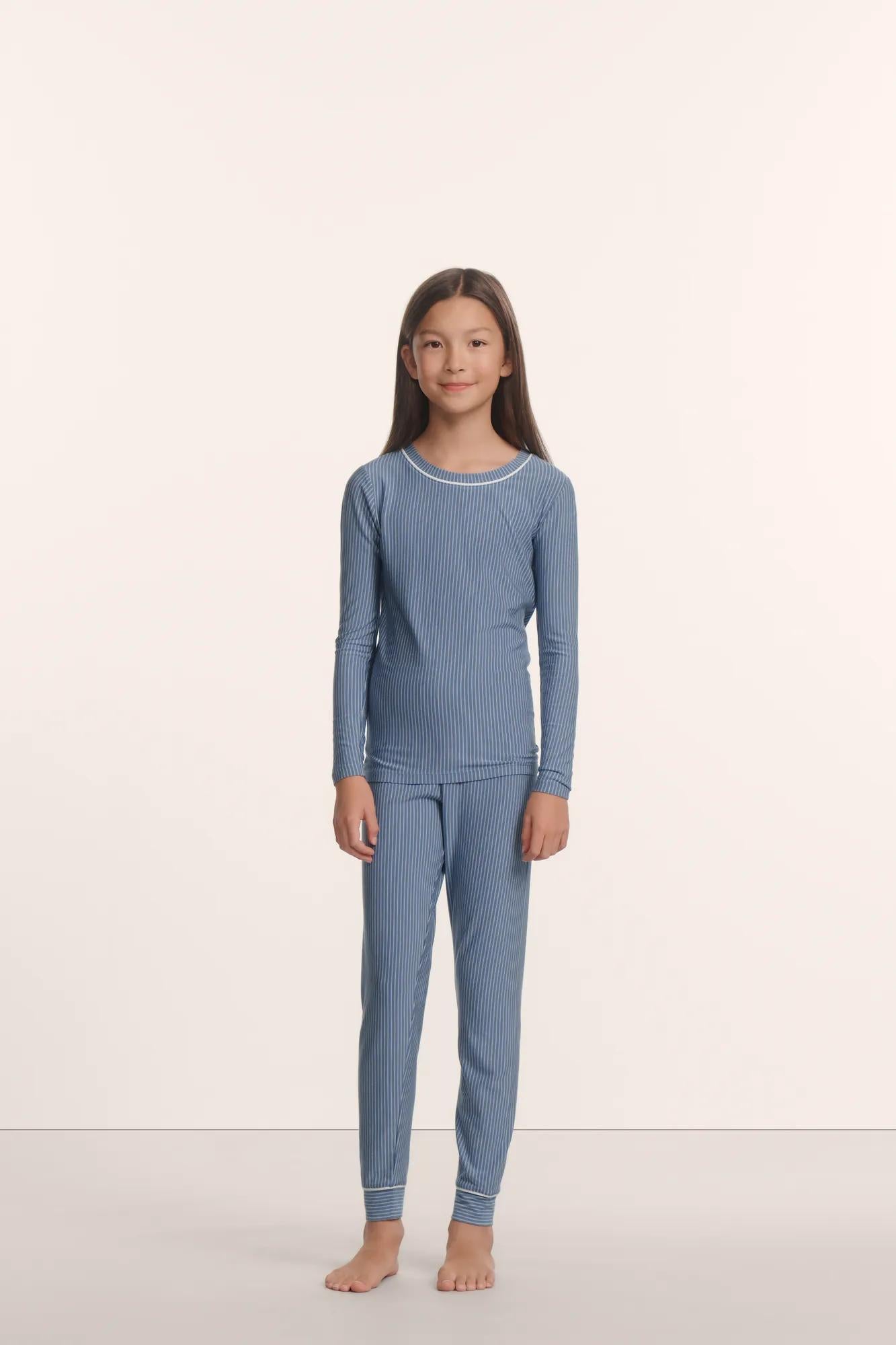Model is wearing Kids Printed TENCEL™ Modal Unisex Long PJ Set in Duo Stripe Slate Blue/Ivory