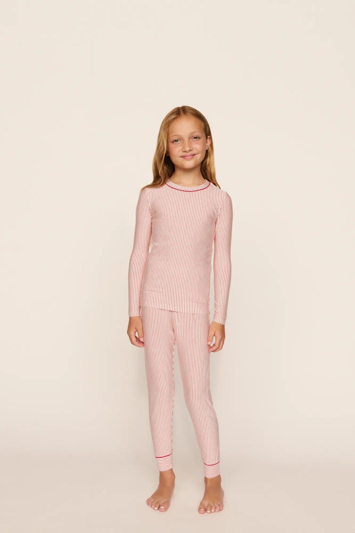 Model is wearing Kids Printed TENCEL™ Modal Unisex Long PJ Set in Duo Stripe Hollyred/Hollyred
