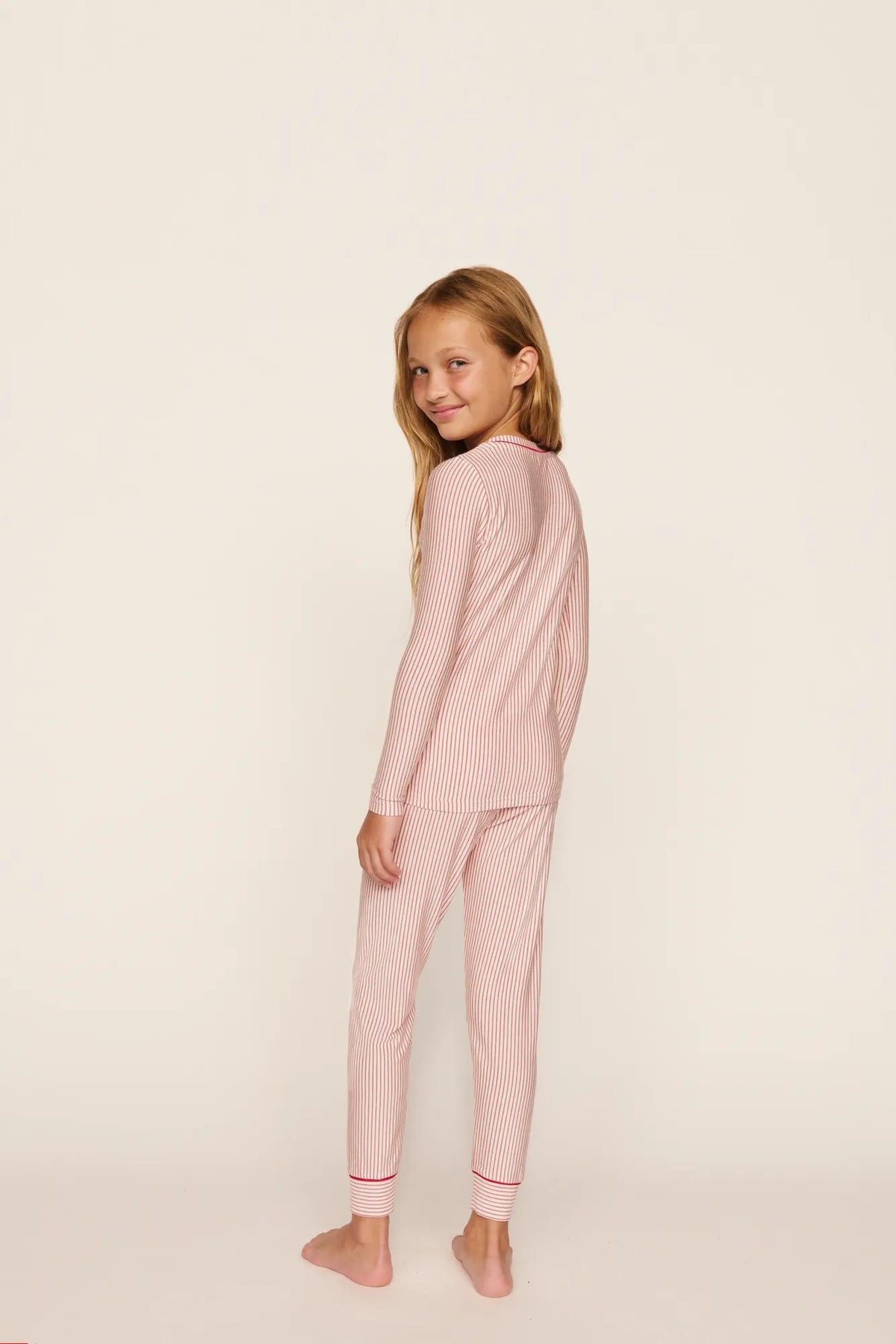Model is wearing Kids Printed TENCEL™ Modal Unisex Long PJ Set in Duo Stripe Hollyred/Hollyred