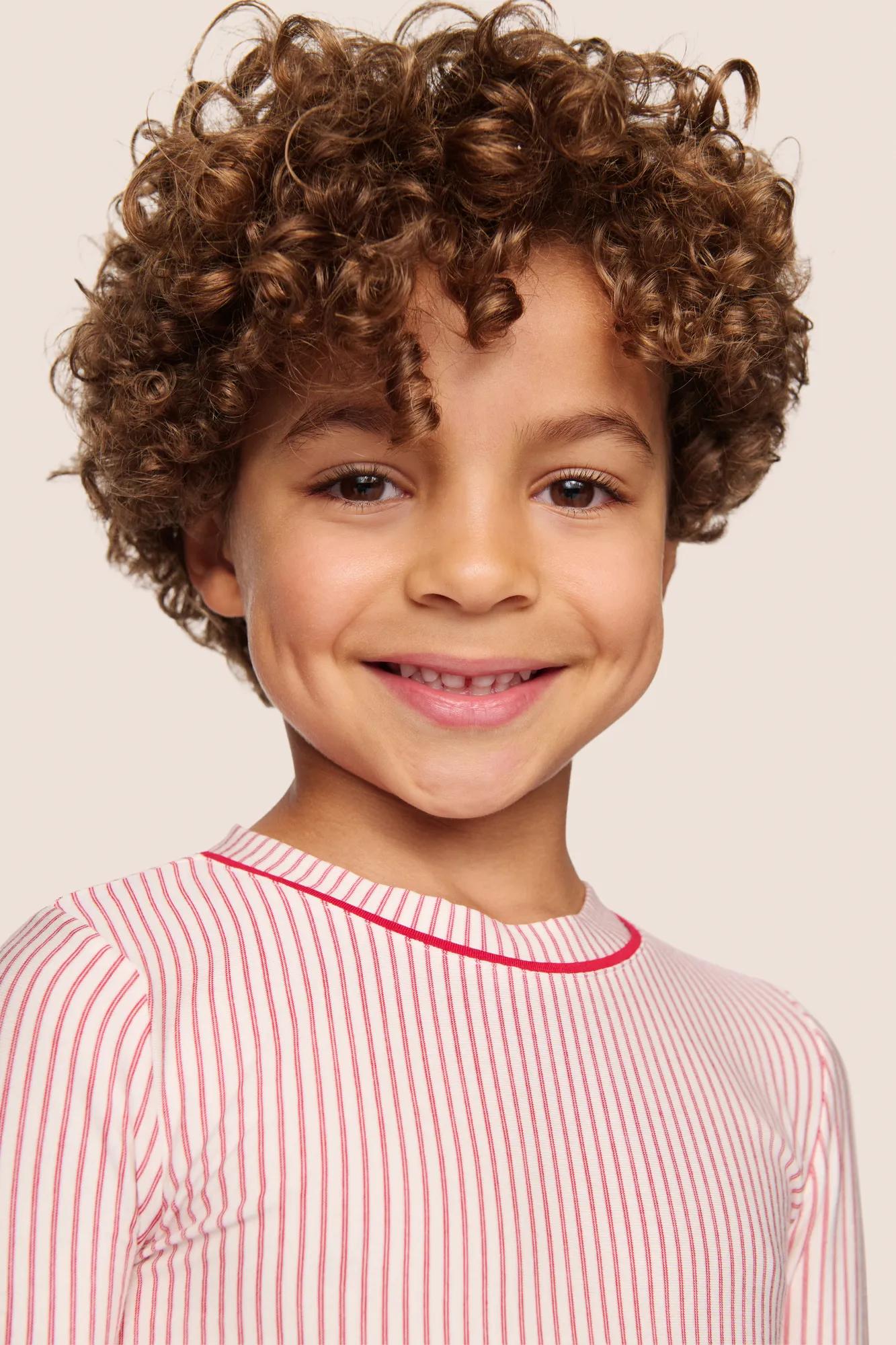 Model is wearing Kids Printed TENCEL™ Modal Unisex Long PJ Set  in Duo Stripe Hollyred/Hollyred