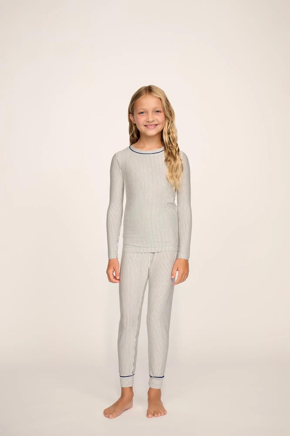 Model is wearing Kids Printed TENCEL™ Modal Unisex Long PJ Set in Duo Stripe Ivory/Navy