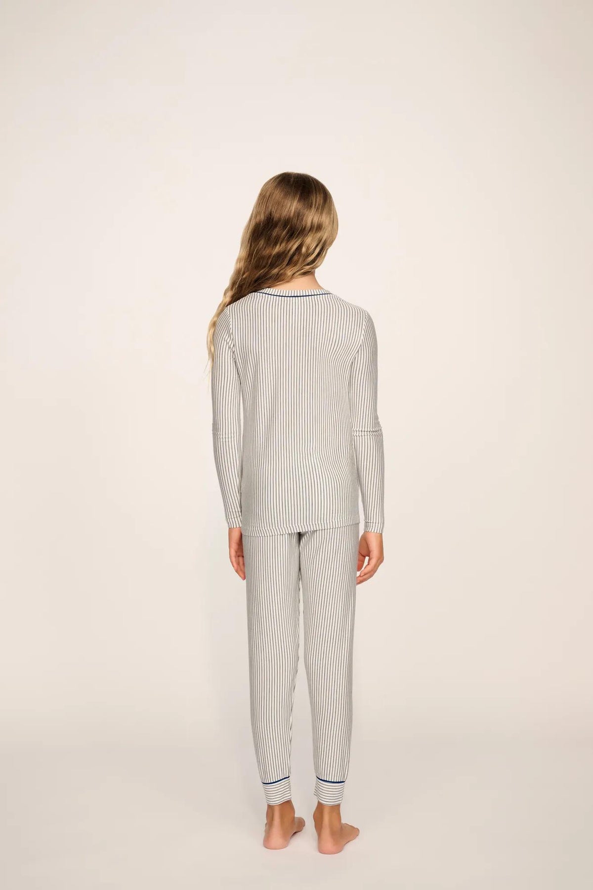 Model is wearing Kids Printed TENCEL™ Modal Unisex Long PJ Set in Duo Stripe Ivory/Navy