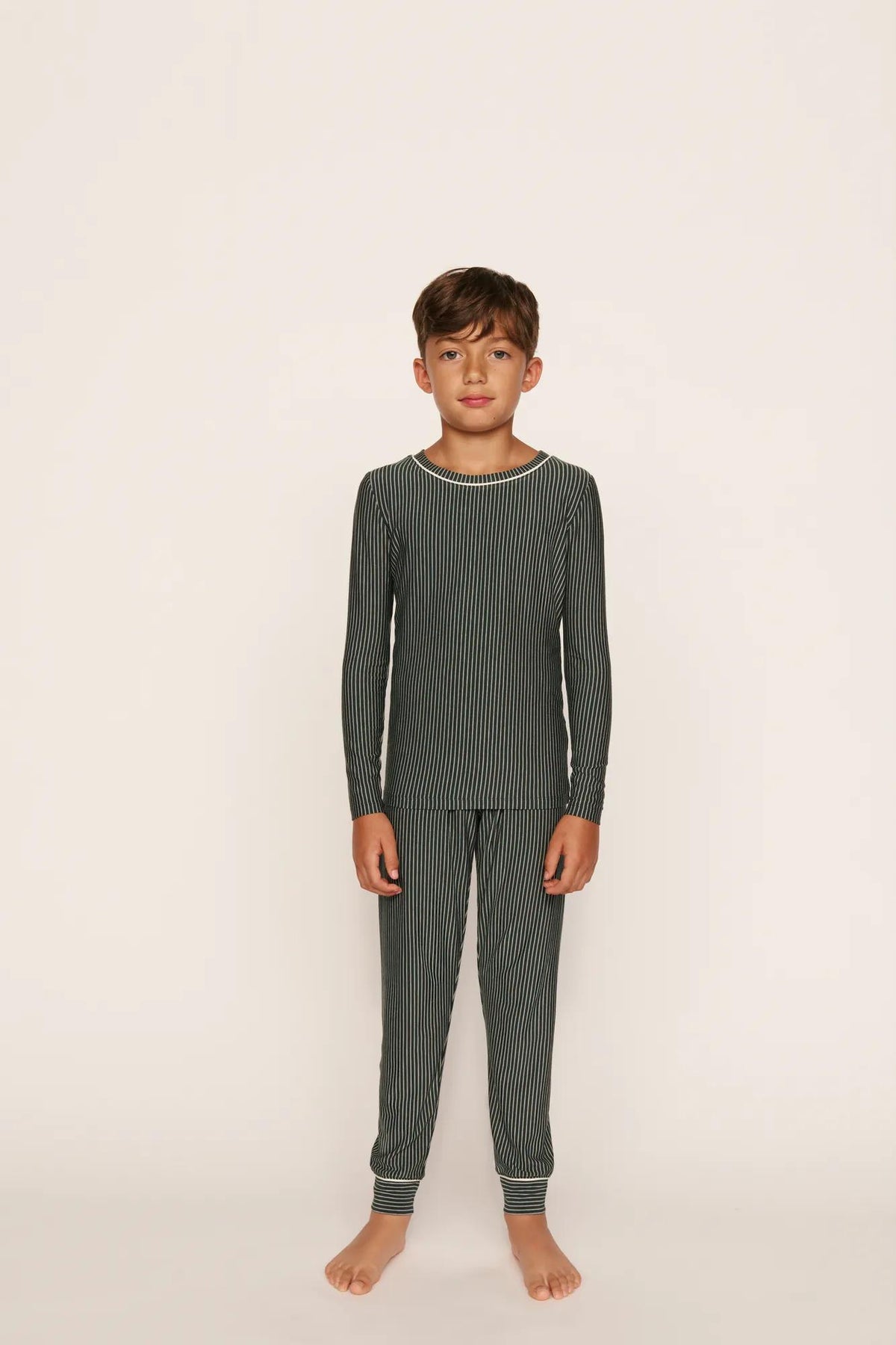 Model is wearing Kids Printed TENCEL™ Modal Unisex Long PJ Set in Duo Stripe Pine/Ivory