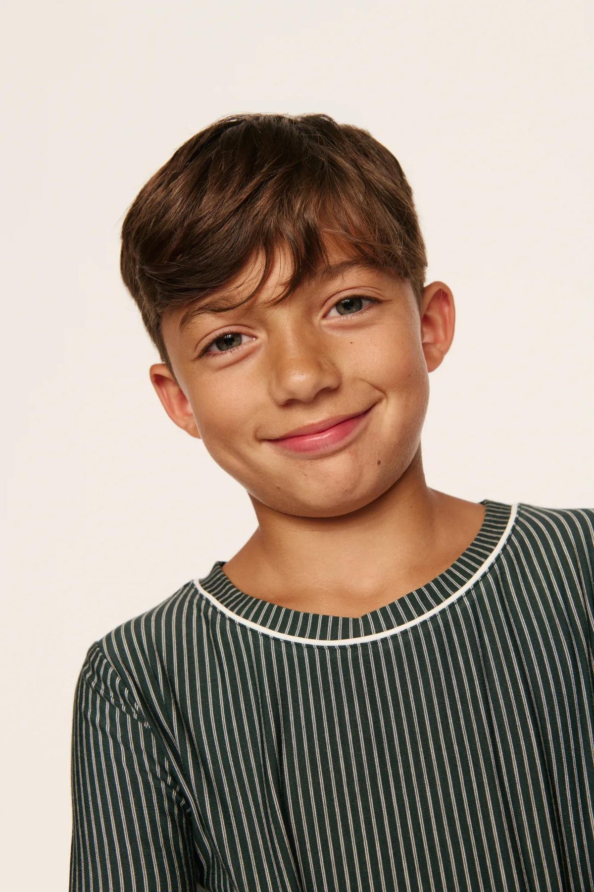 Model is wearing Kids Printed TENCEL™ Modal Unisex Long PJ Set in Duo Stripe Pine/Ivory