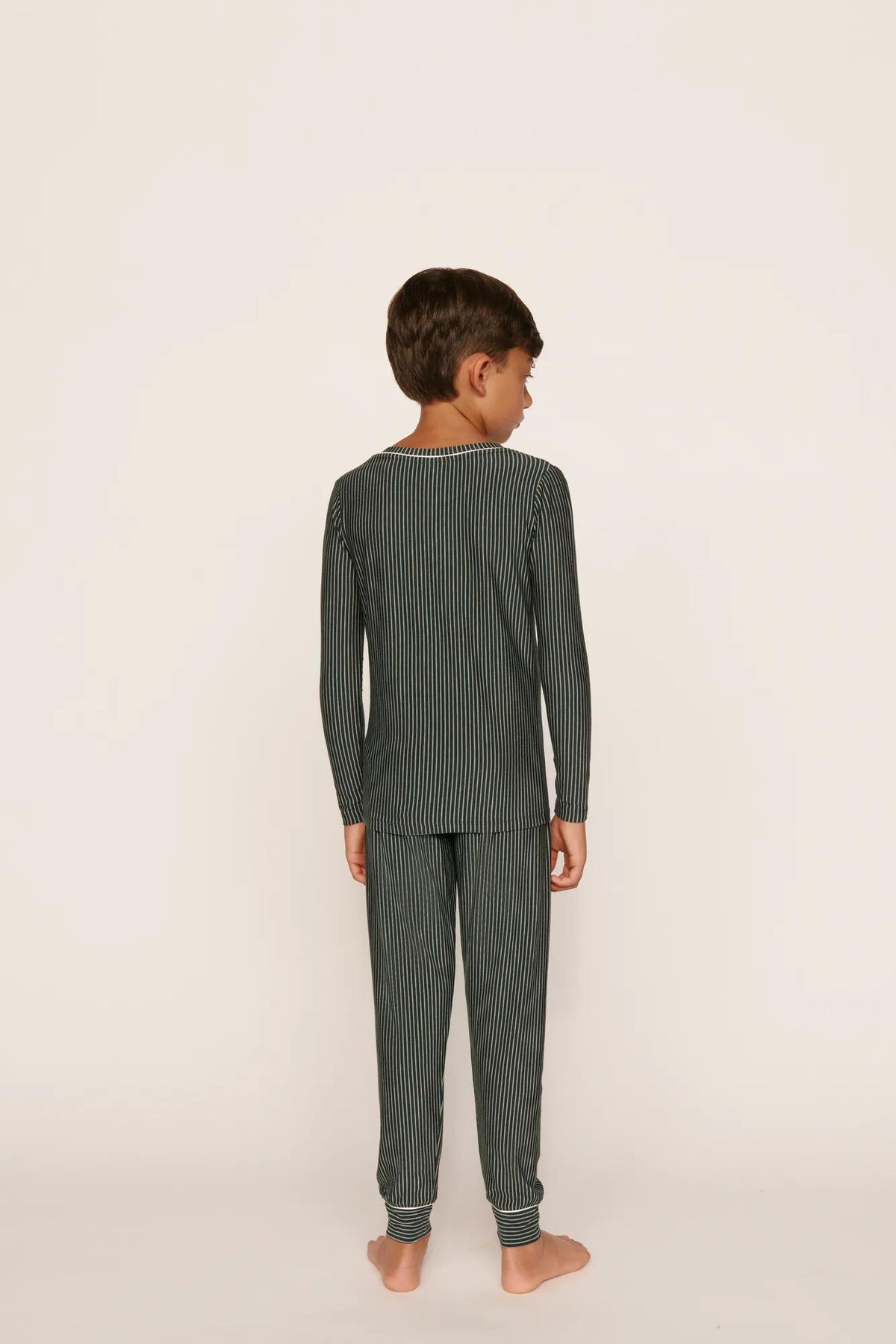 Model is wearing Kids Printed TENCEL™ Modal Unisex Long PJ Set in Duo Stripe Pine/Ivory