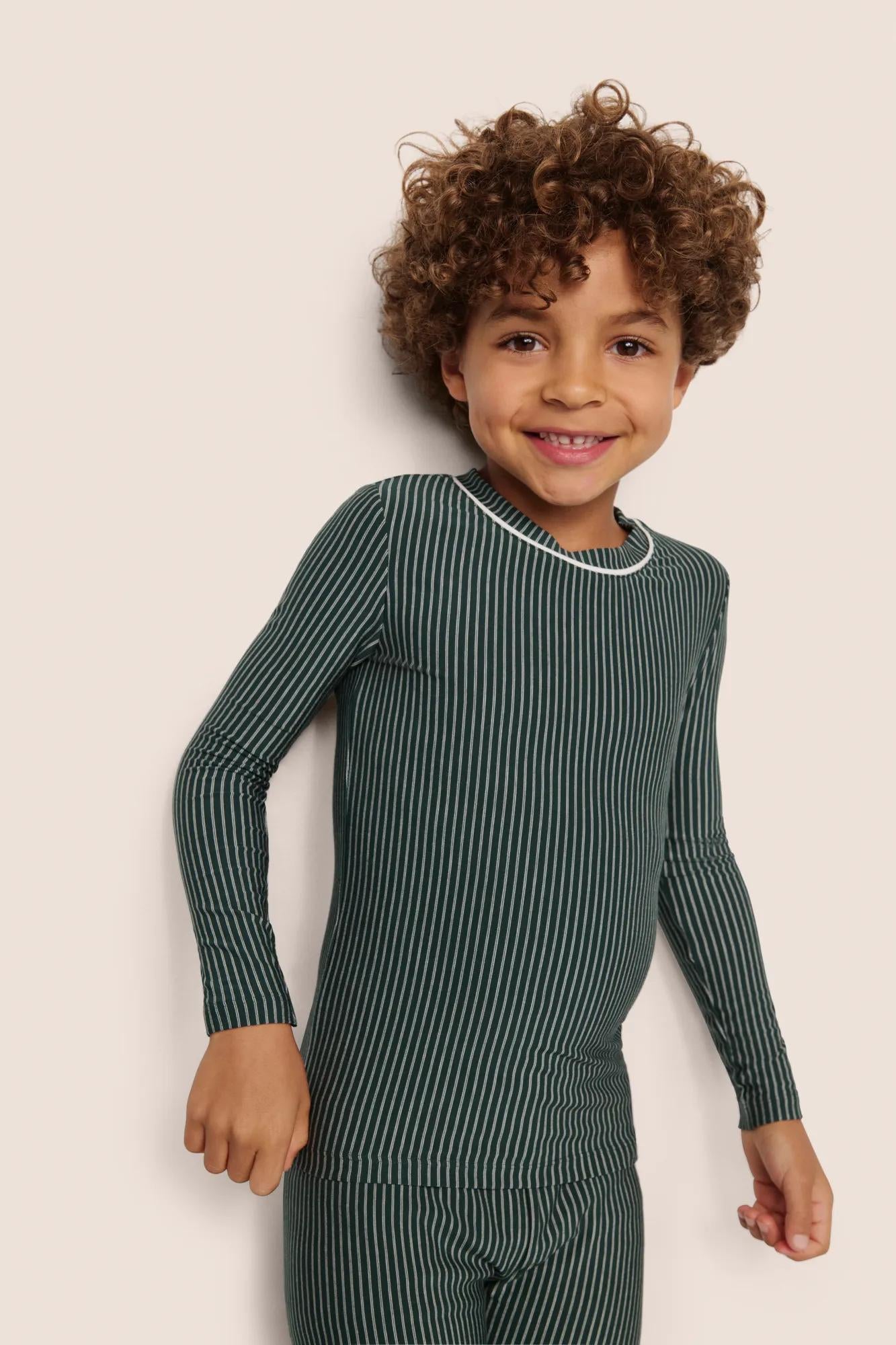 Model is wearing Kids Printed TENCEL™ Modal Unisex Long PJ Set  in Duo Stripe Pine/Ivory
