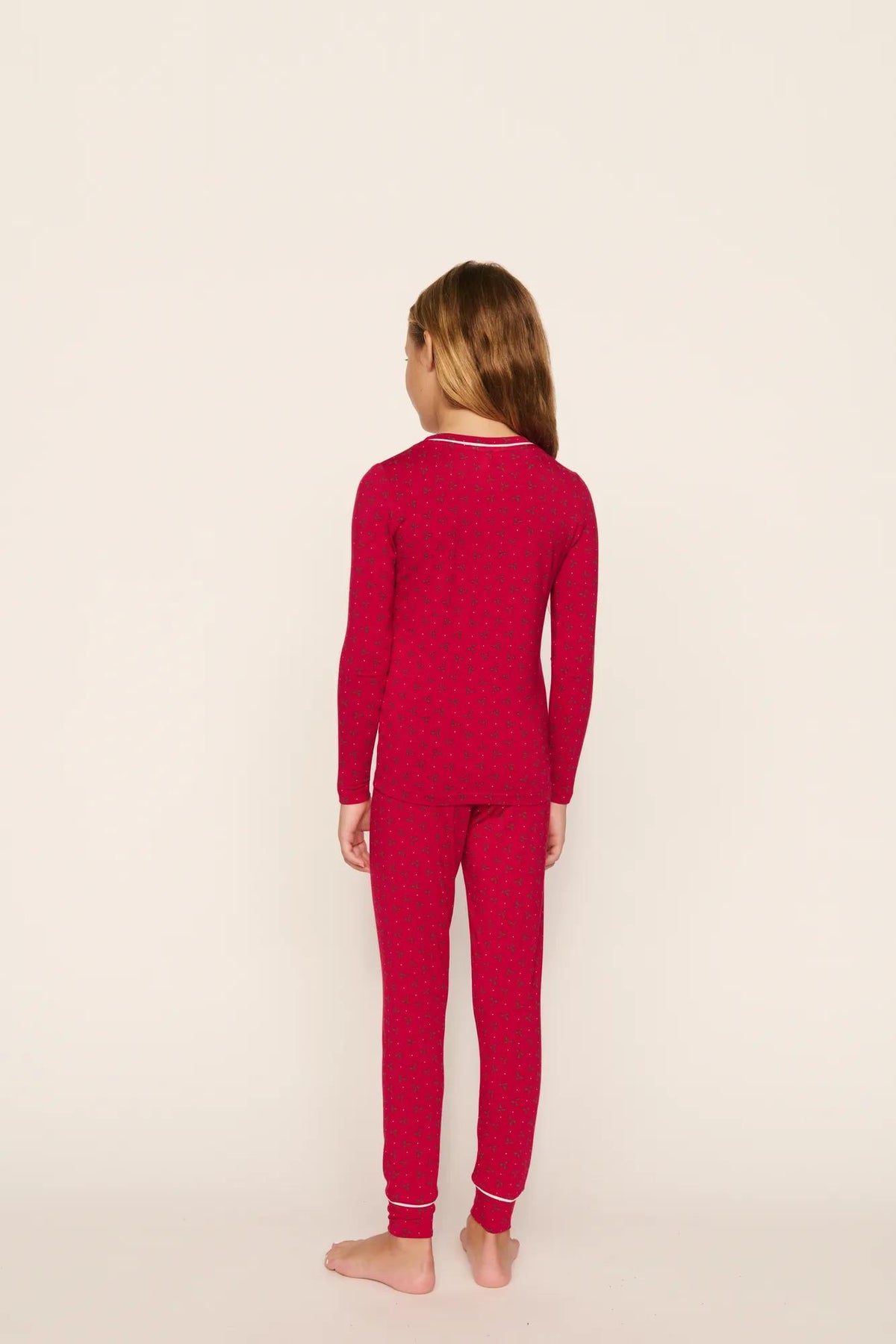 Model is wearing Kids Printed TENCEL™ Modal Unisex Long PJ Set in Hollyberry Holly Red/Ivory