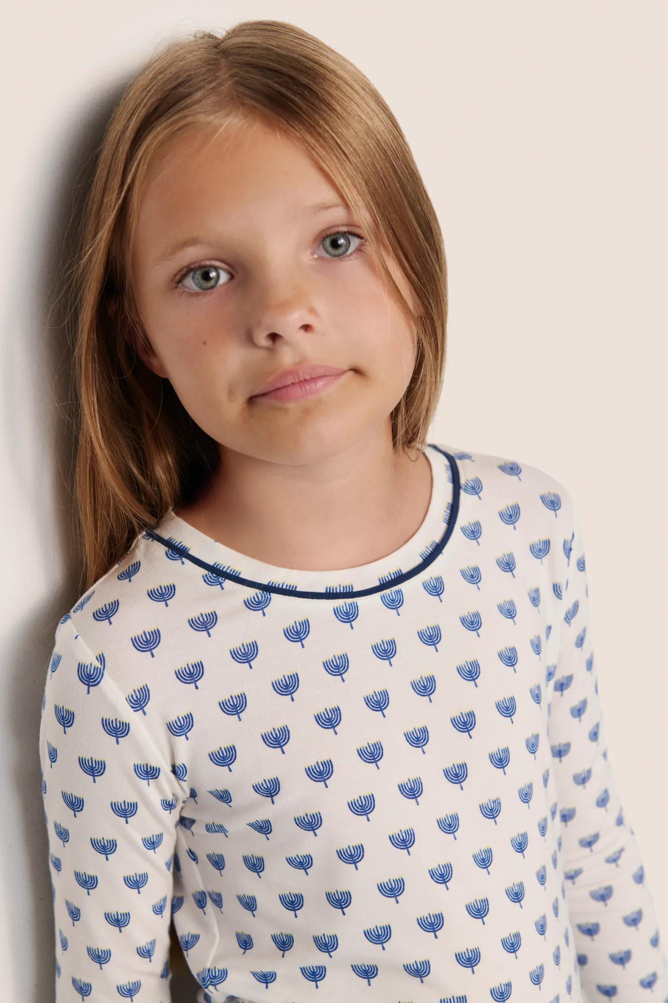 Model is wearing Kids Printed TENCEL™ Modal Unisex Long PJ Set  in Hannukah Glow Nouvean Navy/Ny