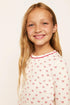 Model is wearing Kids Printed TENCEL™ Modal Unisex Long PJ Set in Mini Bow Ivory/Holly Red