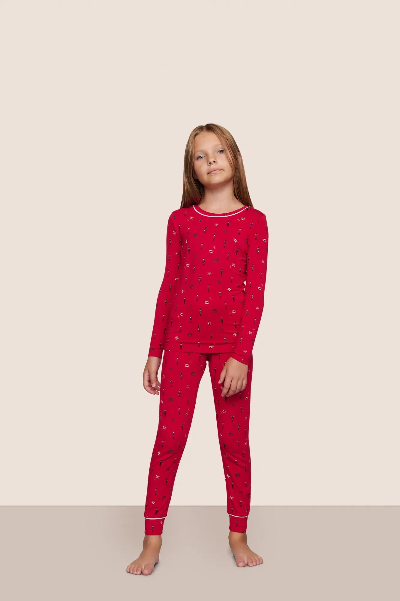 Model is wearing Kids Printed TENCEL™ Modal Unisex Long PJ Set  in Nutcracker Holly Red/Ivory