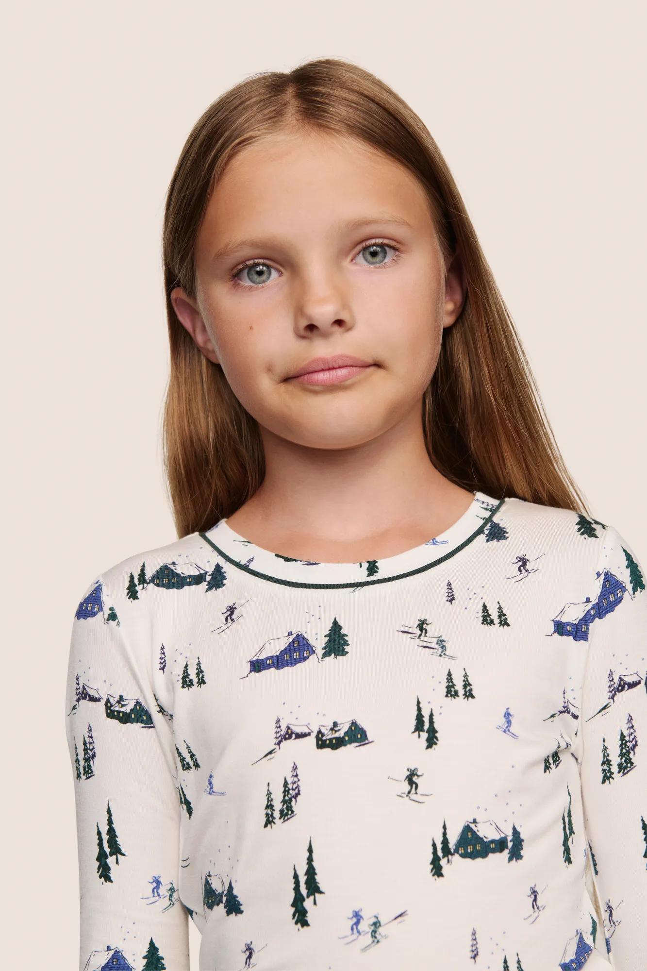 Model is wearing Kids Printed TENCEL™ Modal Unisex Long PJ Set  in Ski Chalet Ivory/Pine