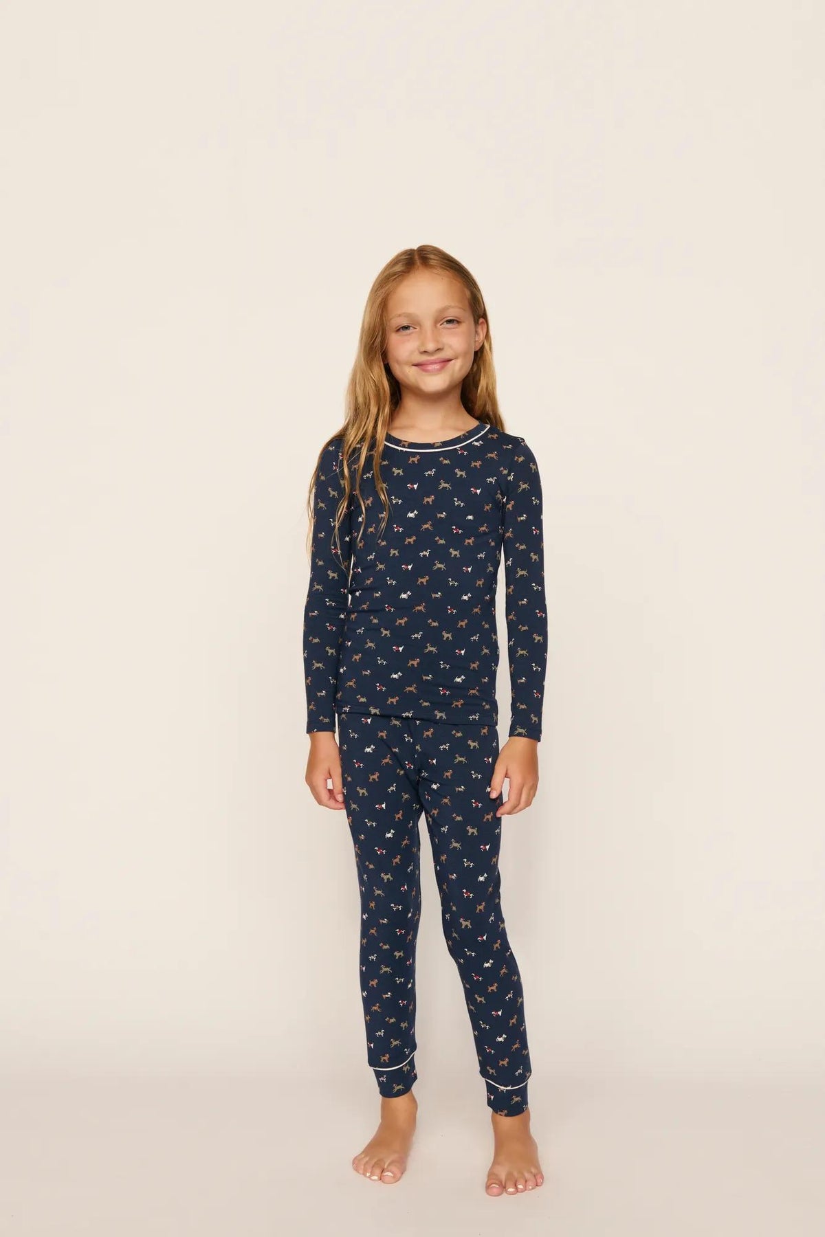 Model is wearing Kids Printed TENCEL™ Modal Unisex Long PJ Set in Santa Paws Navy/Ivory