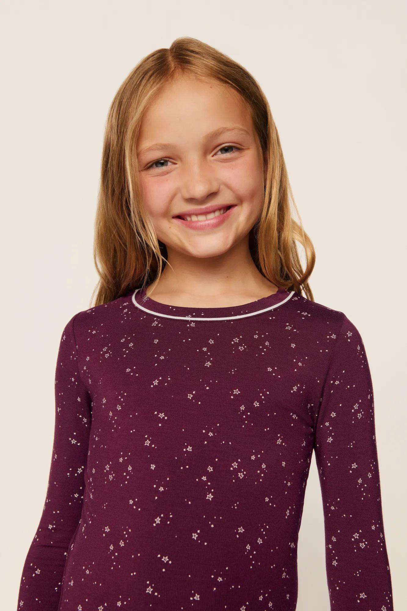 Model is wearing Kids Printed TENCEL™ Modal Unisex Long PJ Set in Starlight Wildberry/Ivory