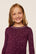 Model is wearing Kids Printed TENCEL™ Modal Unisex Long PJ Set in Starlight Wildberry/Ivory