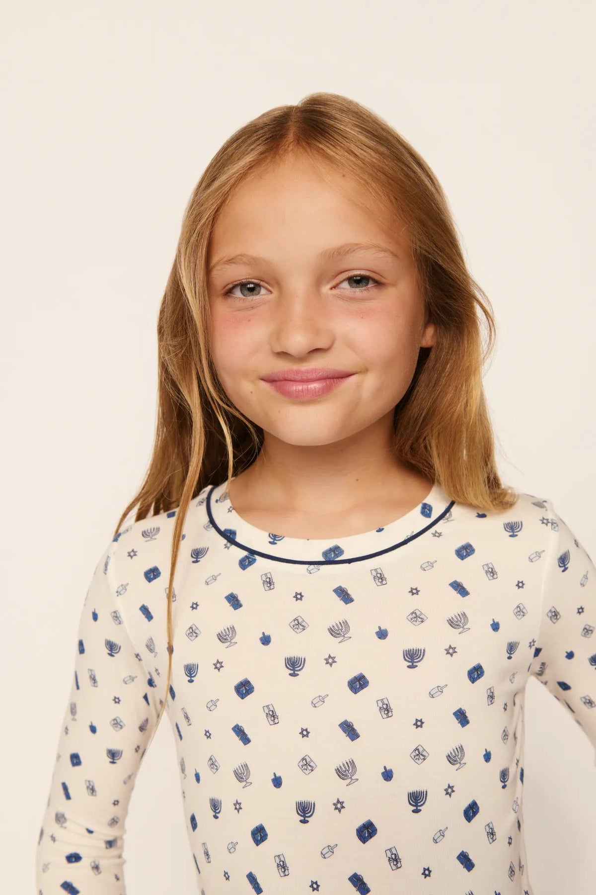 Model is wearing Kids Printed TENCEL™ Modal Unisex Long PJ Set in Twinkling Menorah Ivory/Navy