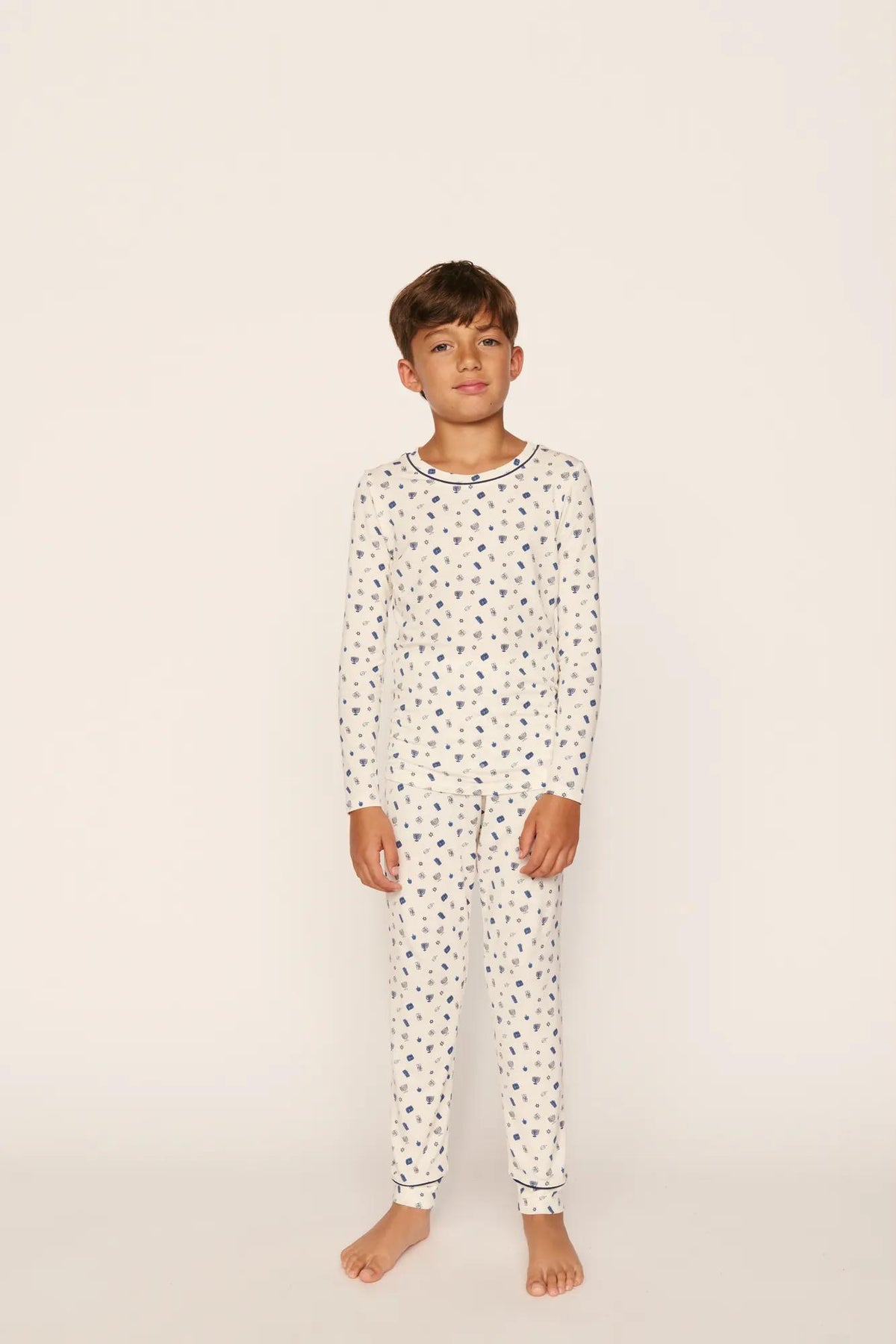 Model is wearing Kids Printed TENCEL™ Modal Unisex Long PJ Set in Twinkling Menorah Ivory/Navy