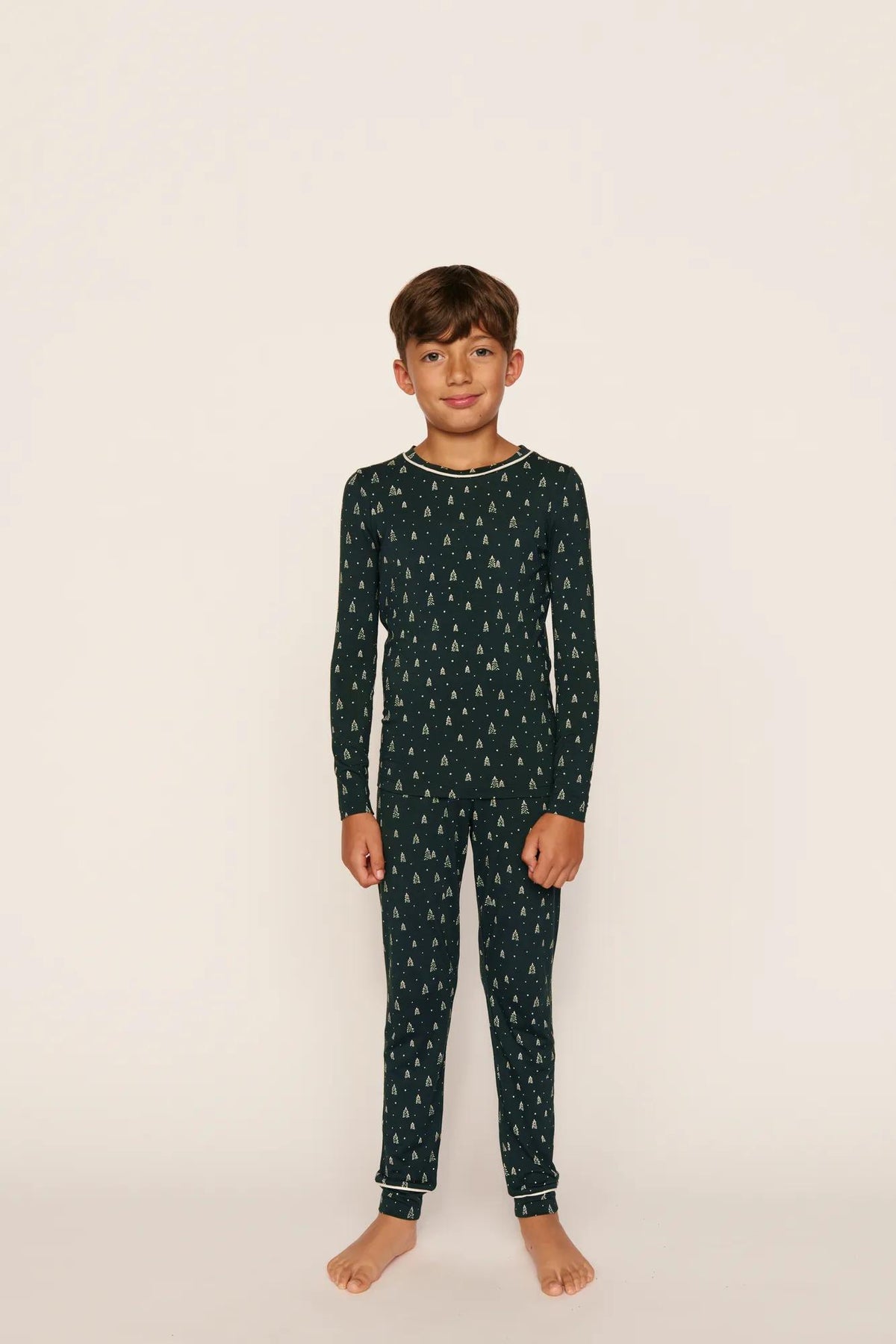 Model is wearing Kids Printed TENCEL™ Modal Unisex Long PJ Set in Winter Pine/Ivory