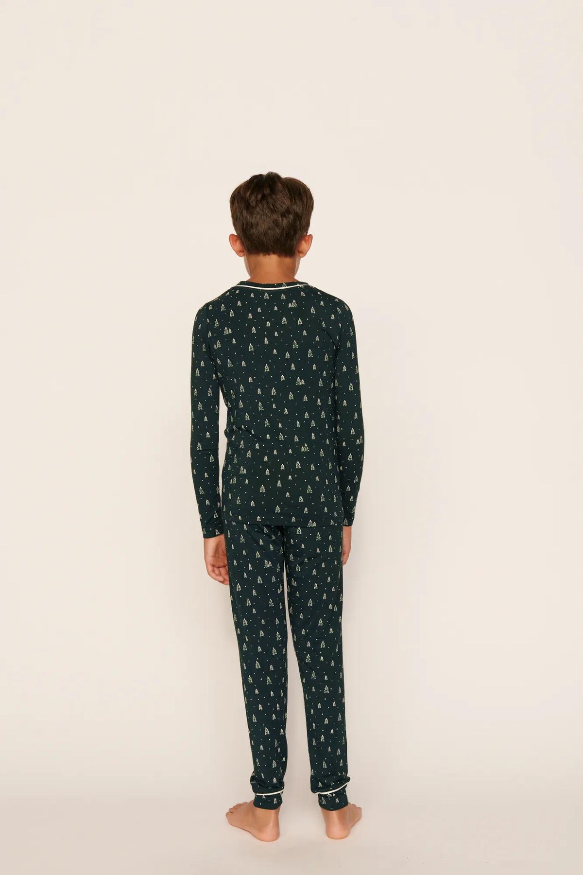 Model is wearing Kids Printed TENCEL™ Modal Unisex Long PJ Set in Winter Pine/Ivory