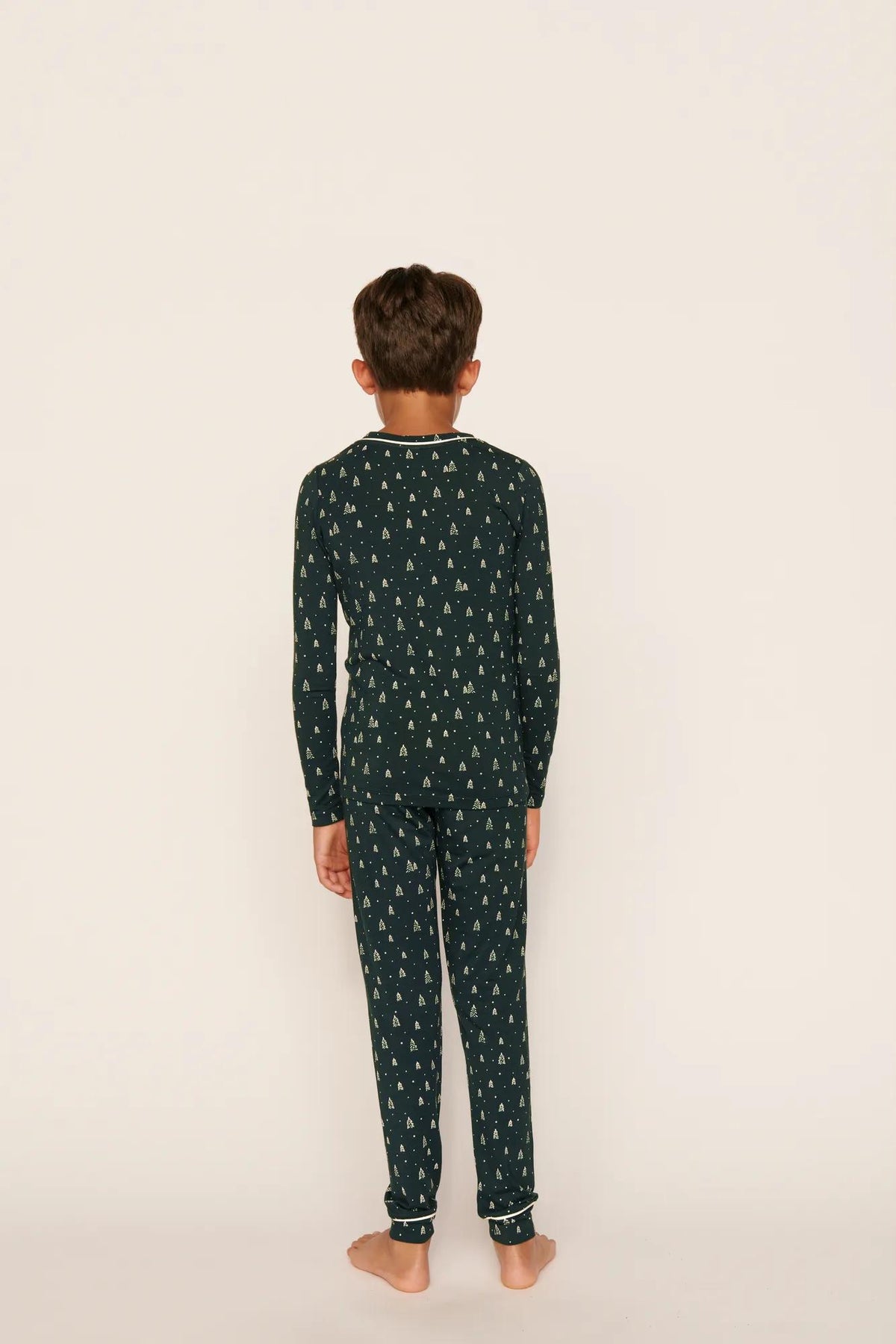Model is wearing Kids Printed TENCEL™ Modal Unisex Long PJ Set in Winter Pine/Ivory