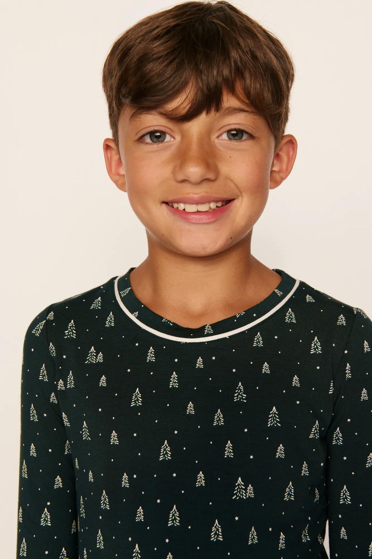 Model is wearing Kids Printed TENCEL™ Modal Unisex Long PJ Set in Winter Pine/Ivory