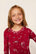 Model is wearing Kids Printed TENCEL™ Modal Unisex Long PJ Set in Winter Skating Holly Red/Ivory