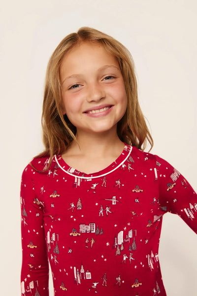 Model is wearing Kids Printed TENCEL™ Modal Unisex Long PJ Set in Winter Skating Holly Red/Ivory