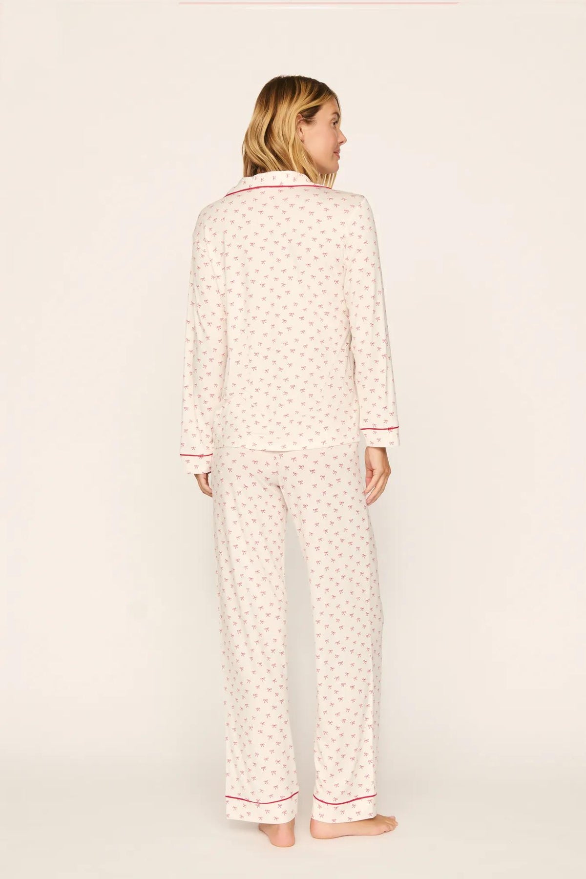 Model is wearing Gisele Printed TENCEL™ Modal Long PJ Set in Mini Bow Ivory/Holly Red